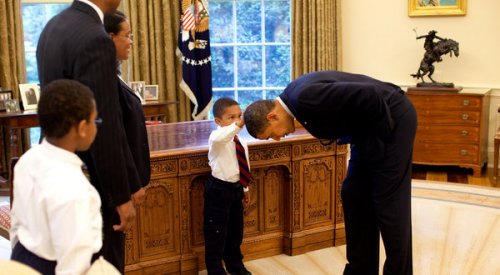 little boy touches obama's head